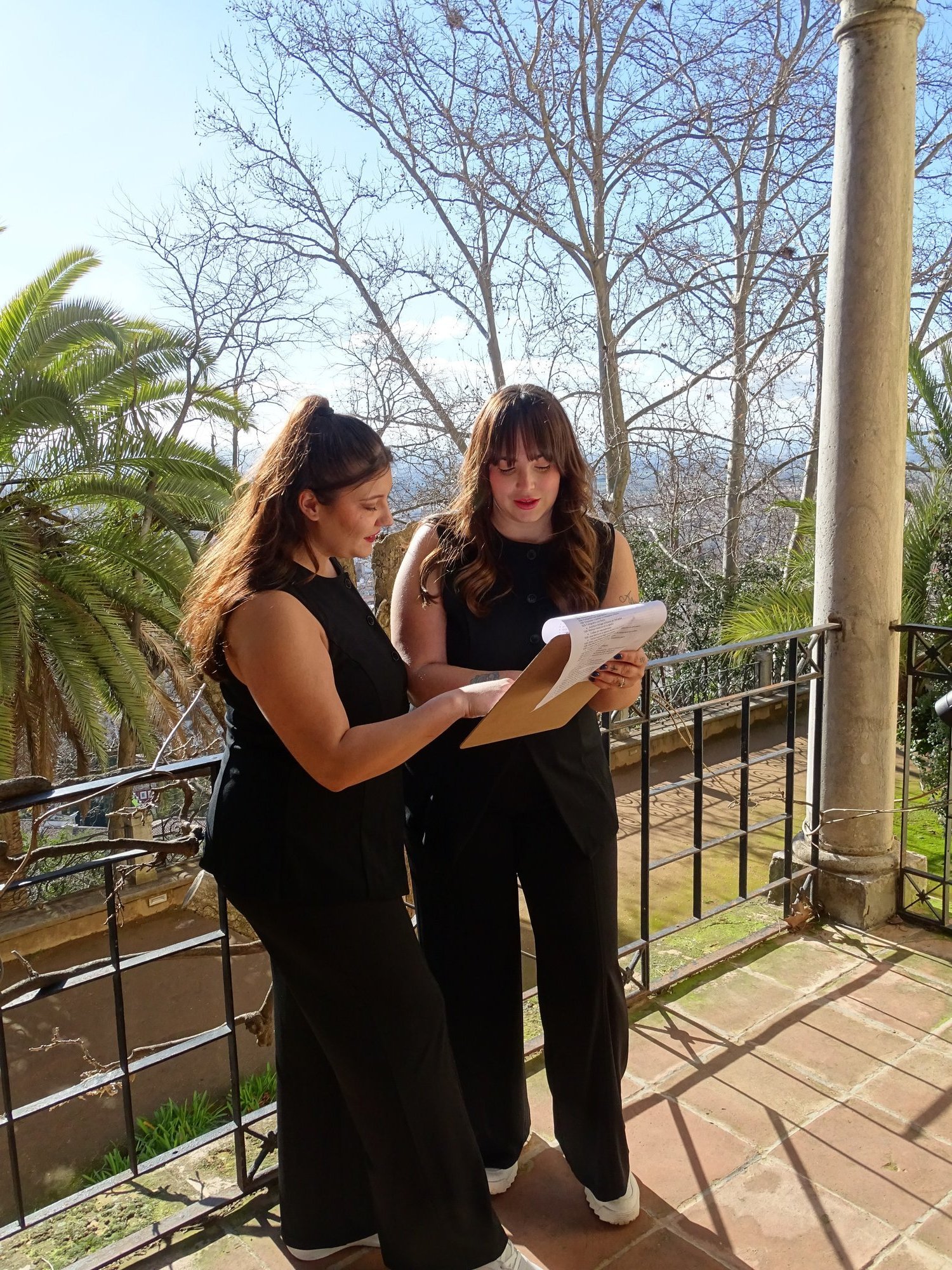 Marina y Eli repasando el guion de una boda en la terraza