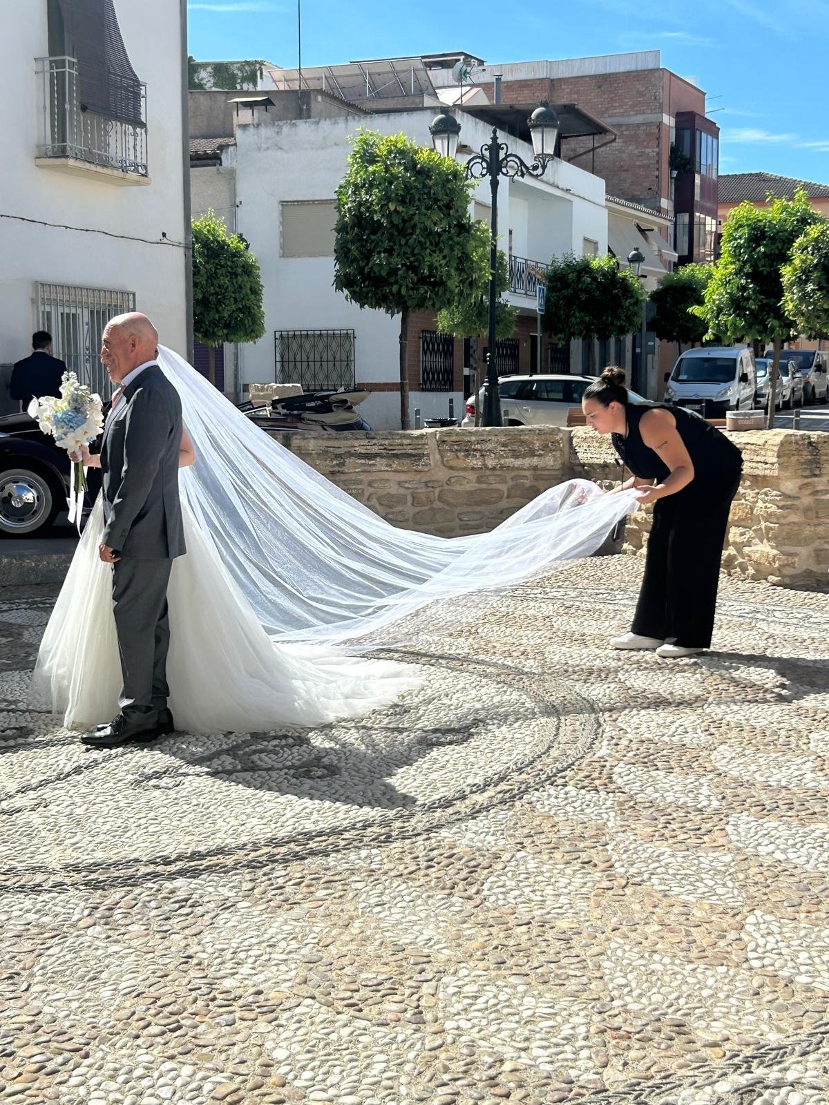 Coordinadora de Mareli Eventos ajustando el velo de la novia antes de la ceremonia en Granada